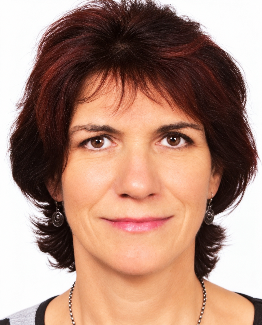 Bild von Britta Schlütter, einer Frau mittleren Alters mit rötlich-braunen Haaren. Sie blickt direkt zur Kamera, mit neutralem Gesichtsausdruck, leichtes, fast unmerkliches Lächeln. Ihr Haar ist in einem geschichteten Stil geschnitten.